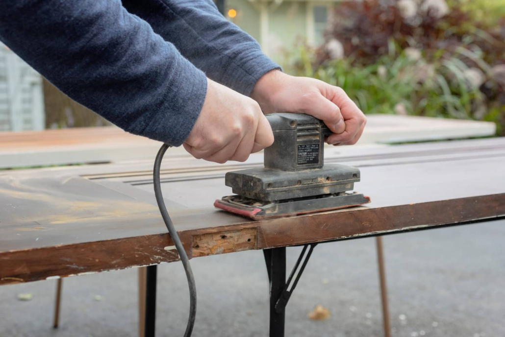 Belt sanding a wood door.