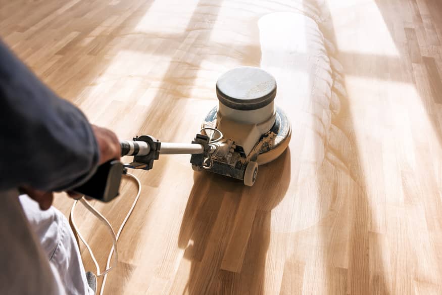 Hire a professional to buff out your hardwood floors and apply a new finish once a year. 