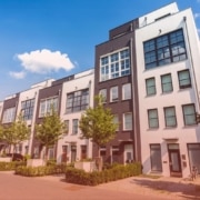 rental inspection checklist A row of modern multi-story apartment buildings with white and dark gray facades on a bright sunny day.