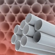 polybutylene pipe Close-up of stacked gray plastic plumbing pipes.