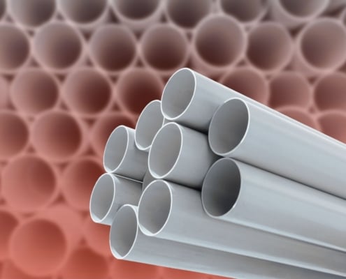Close-up of stacked gray plastic plumbing pipes.