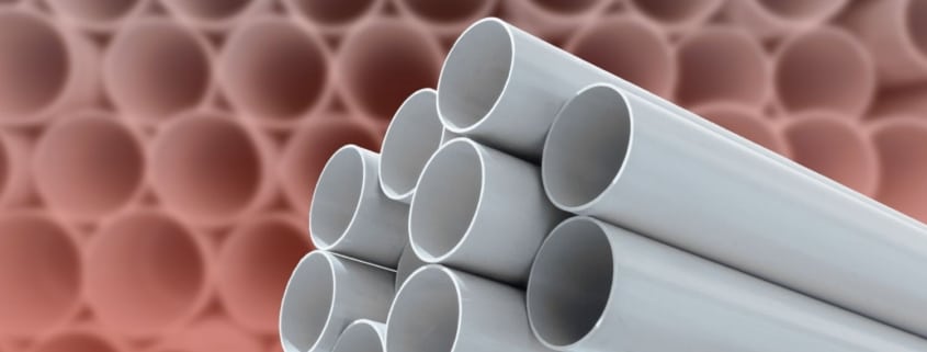 Close-up of stacked gray plastic plumbing pipes.