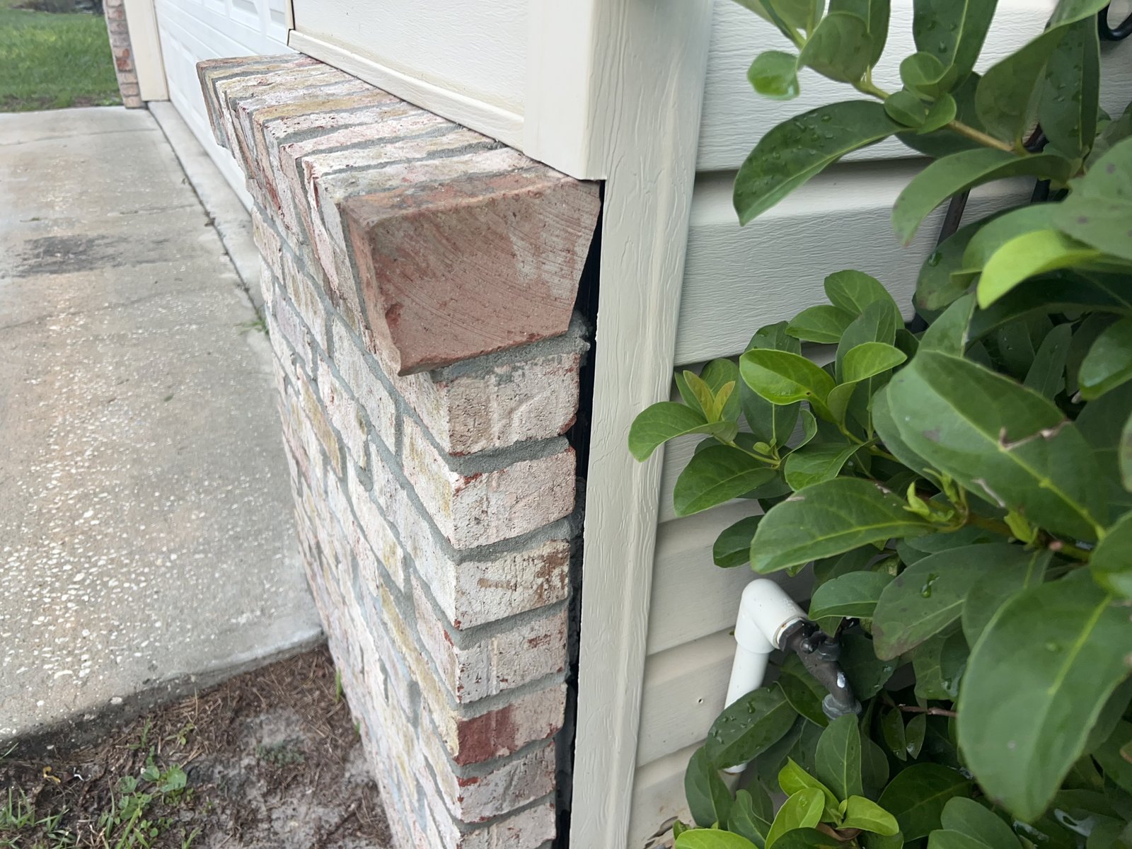 Gap between brick and vinyl siding at a garage corner found during a home inspection